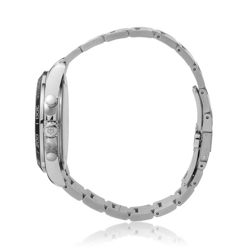 Relógio de pulso de metal prateado, com mostrador preto e detalhes em branco, mostrando cronógrafos e marcações esportivas.