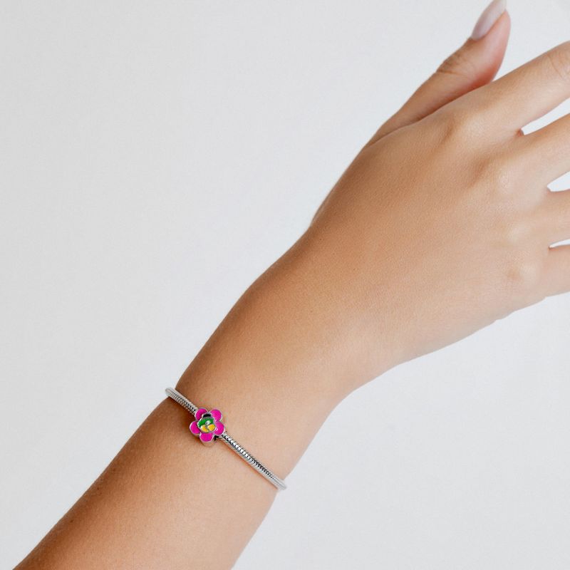 Pulseira com pingente de flor colorida em rosa, verde e amarelo, decorada com detalhes em prata.