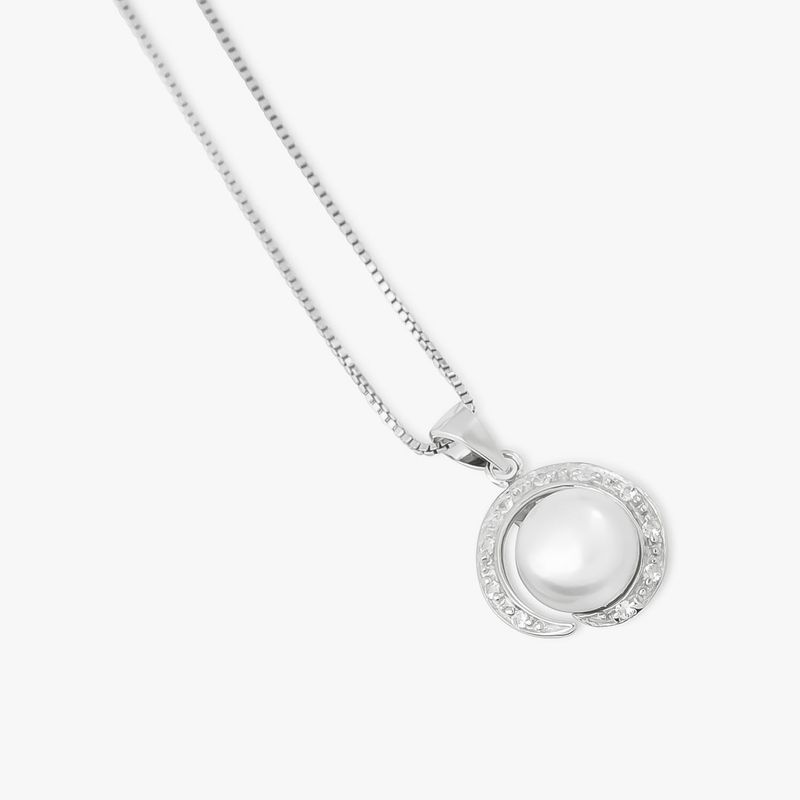 Colar prateado com pingente circular contendo uma pérola central e detalhes com pequenas pedras ao redor.