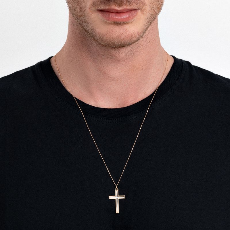 Homem usando uma camiseta preta e um colar dourado com pingente de cruz.
