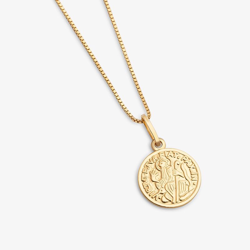 Colar dourado com pingente circular contendo uma figura e inscrição em volta, em fundo branco.
