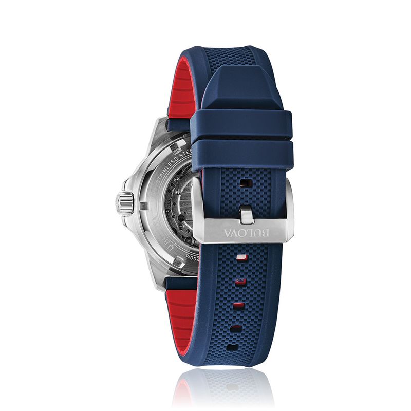 Relógio com pulseira azul de silicone, detalhes em vermelho na parte interna, caixa de aço com visão do mecanismo e marca "Bulova".