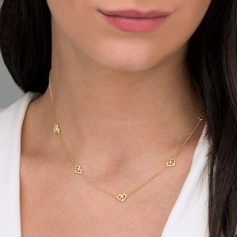 Colar feminino de corrente fina com vários pingentes de coração em ouro.