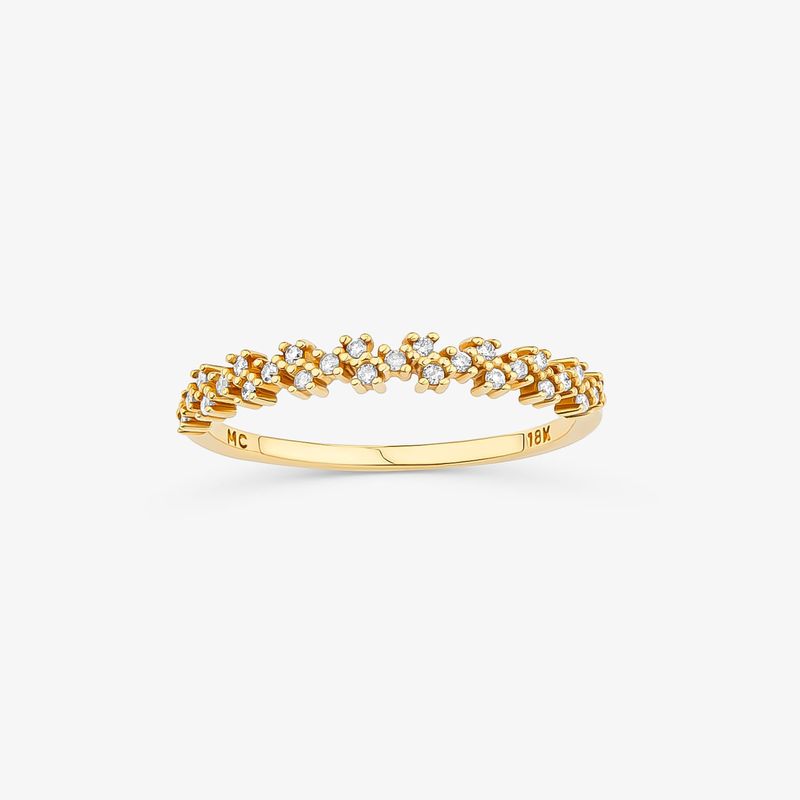 Um elegante anel de ouro com uma fileira de pequenos diamantes dispostos em um padrão floral.