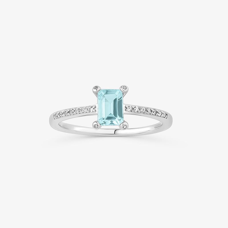Um elegante anel de prata com uma grande pedra preciosa retangular azul-clara e pequenas pedras transparentes ao longo do aro.