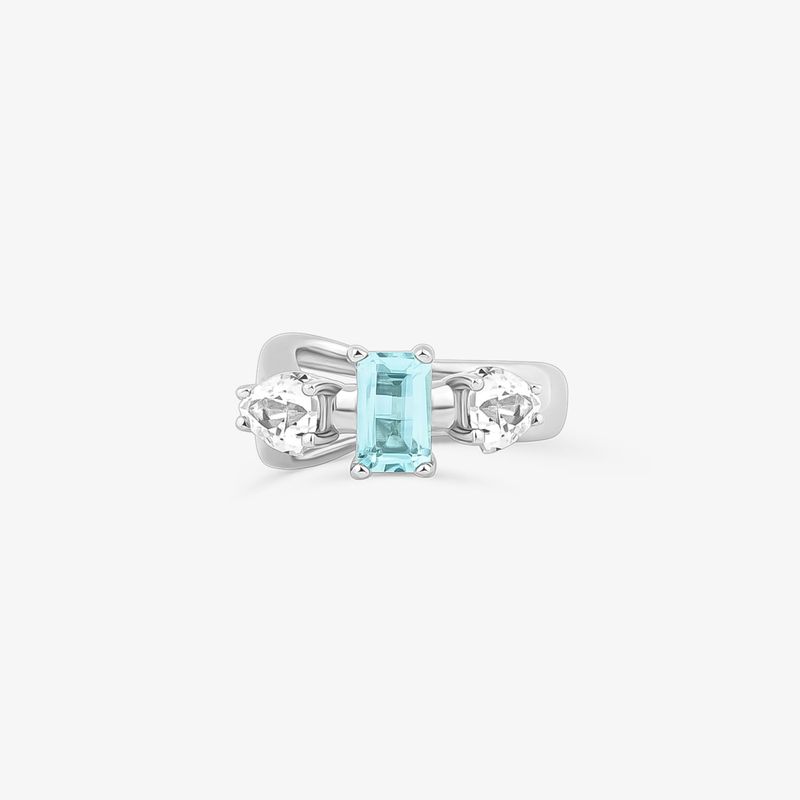 Anelo com uma pedra central azul rectangular e duas pedras transparentes em cada lado, tudo em uma argola de metal prateado.