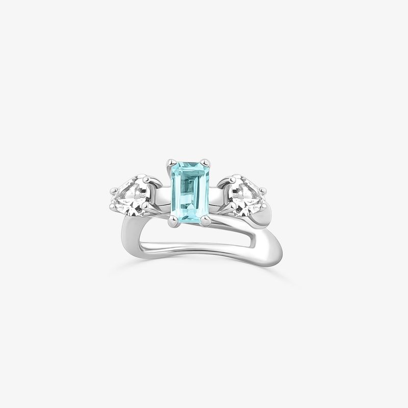 Anel de prata com uma pedra central retangular azul e duas pedras laterais em formato de coração.