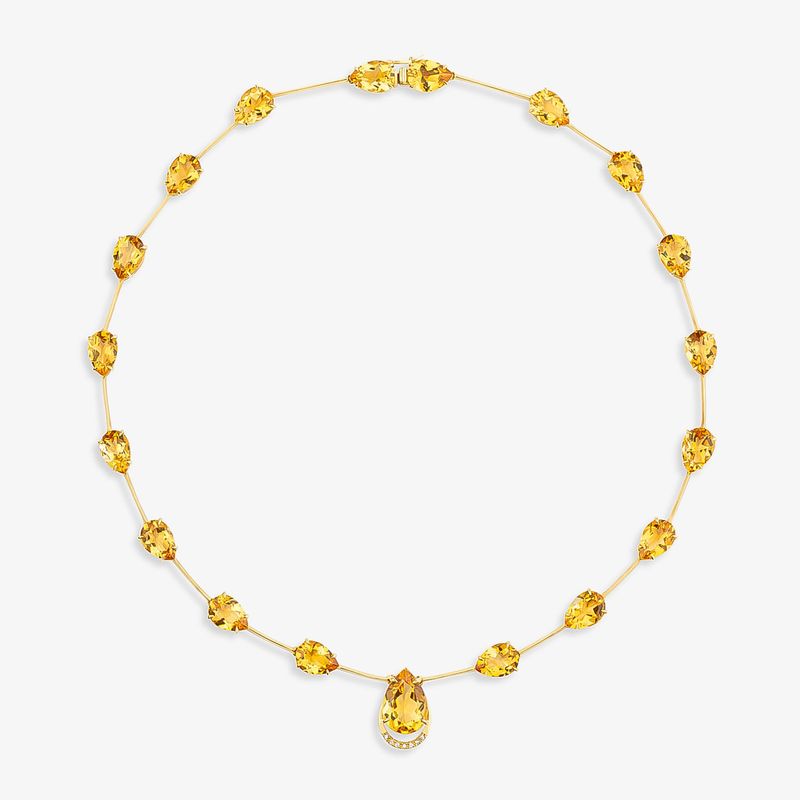 Colar de ouro com pedras amarelas, contendo um pingente central maior.