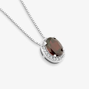 Colar com pingente oval com pedra escura central e aro de pequenas pedras transparentes ao redor, em fundo branco.