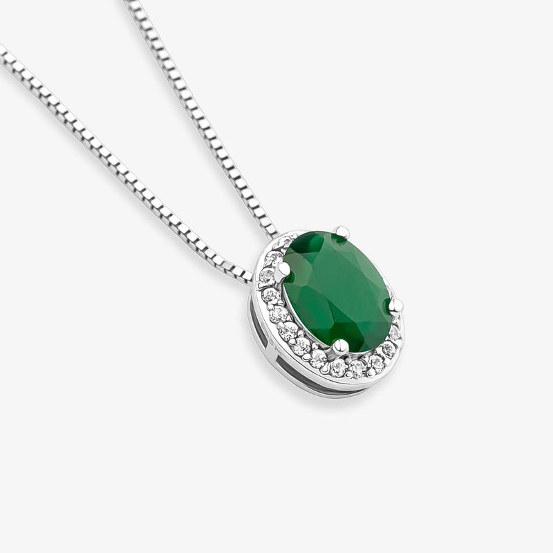 Colar com pingente oval verde escuro e detalhe de pedras brancas ao redor, em fundo branco.
